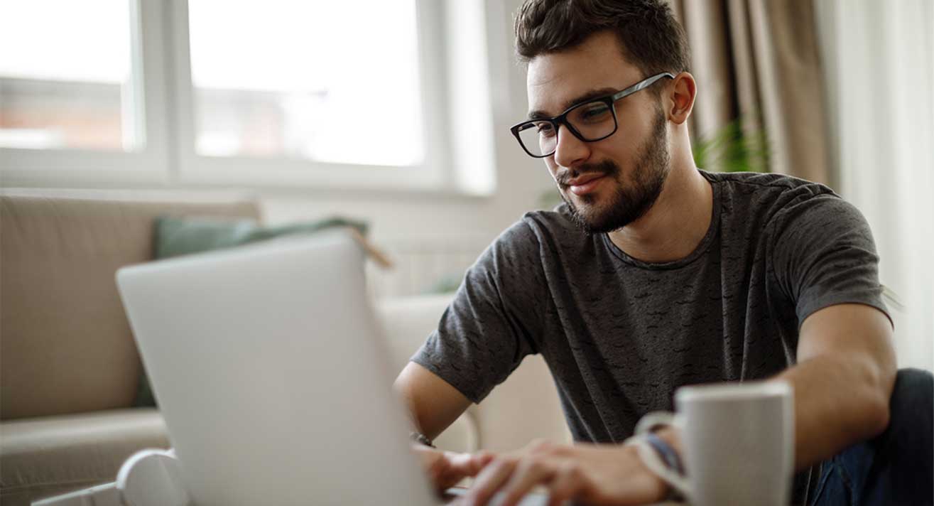 A man works on his laptop. 