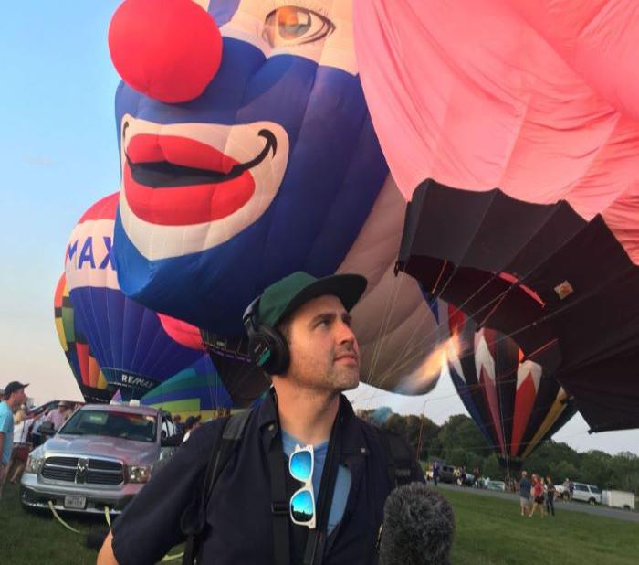 Timothy Maddocks stands in front of hot air balloons.